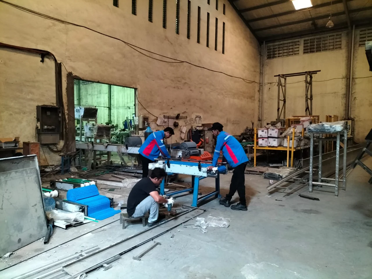 Technicians assembling conveyor equipment in a workshop